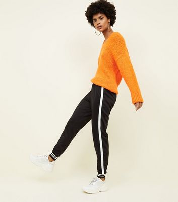 black joggers with orange stripe