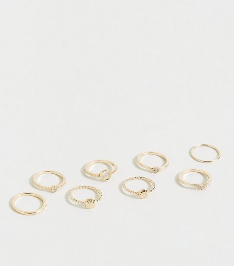 Lot de 8 bagues à superposer dorées à effet martelé et en strass