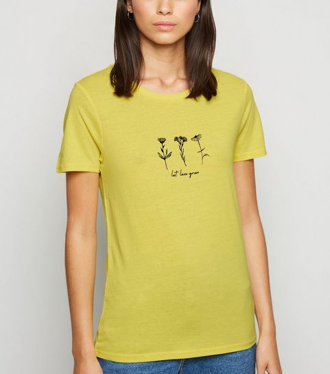 Gelbes T-Shirt mit Blumenmuster und „Let Love Grow”-Slogan