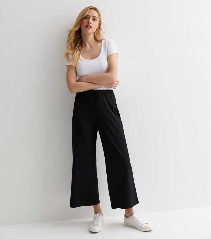 https://media3.newlookassets.com/i/newlook/891776801/womens/clothing/trousers/black-ribbed-drawstring-wide-leg-crop-trousers.jpg?strip=true&qlt=50&w=720